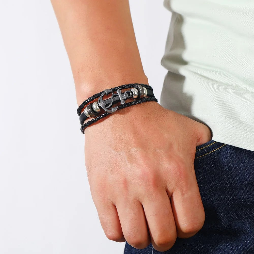 A close-up of a man’s wrist adorned with a striking skull and crossbones bracelet, highlighting his unique fashion sense.