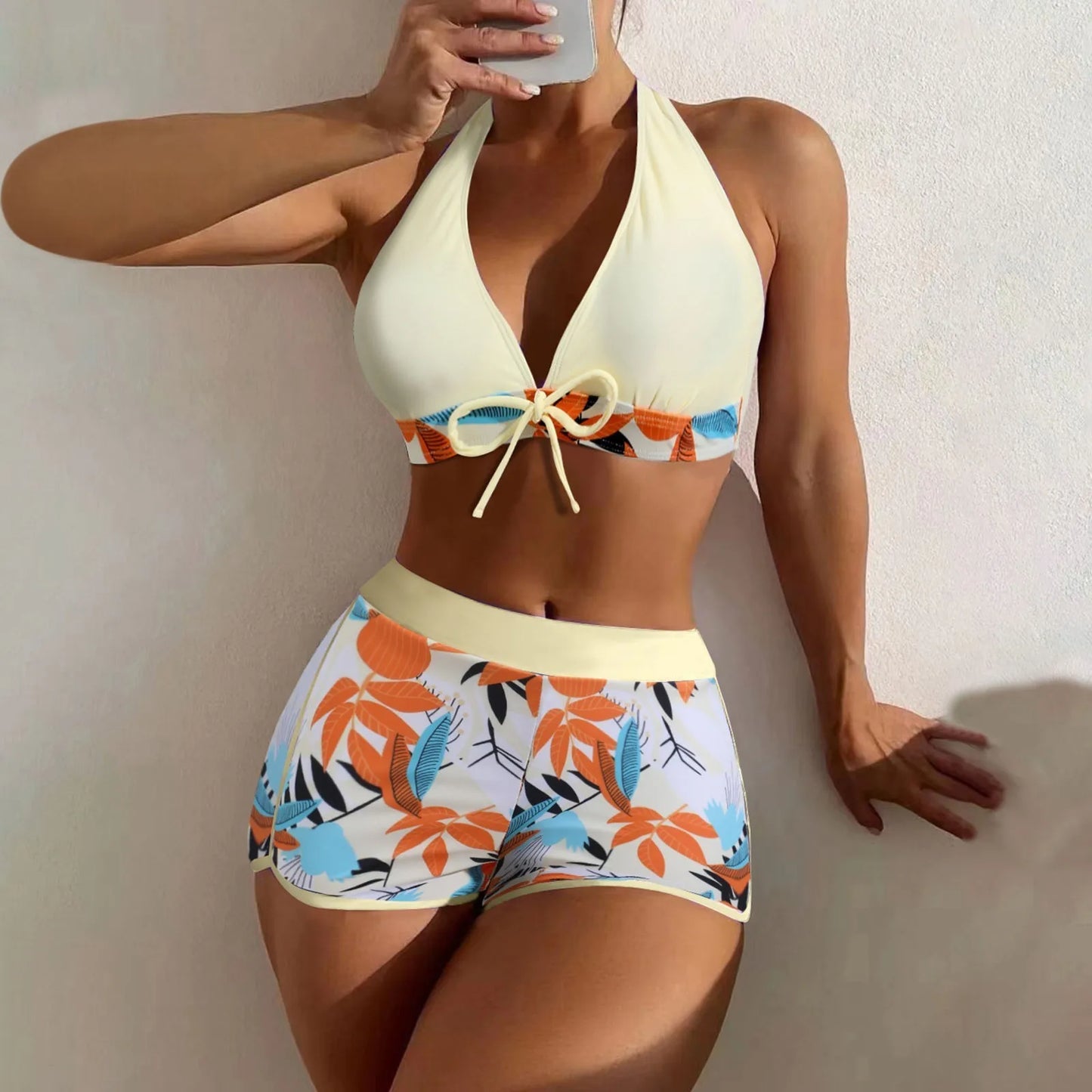 Woman wearing a colorful bikini with a plain background