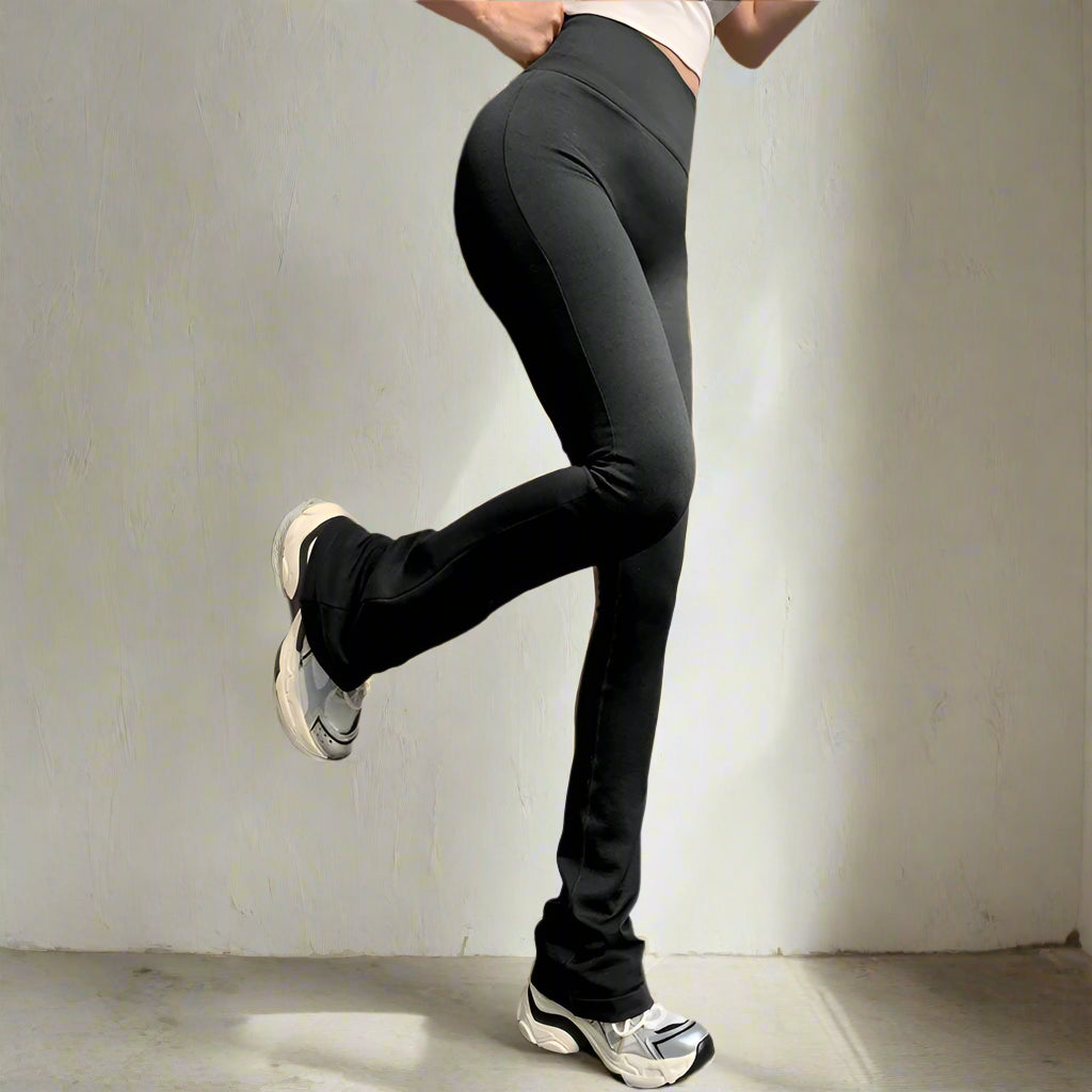 Person wearing black leggings and white sneakers stepping onto a platform.
