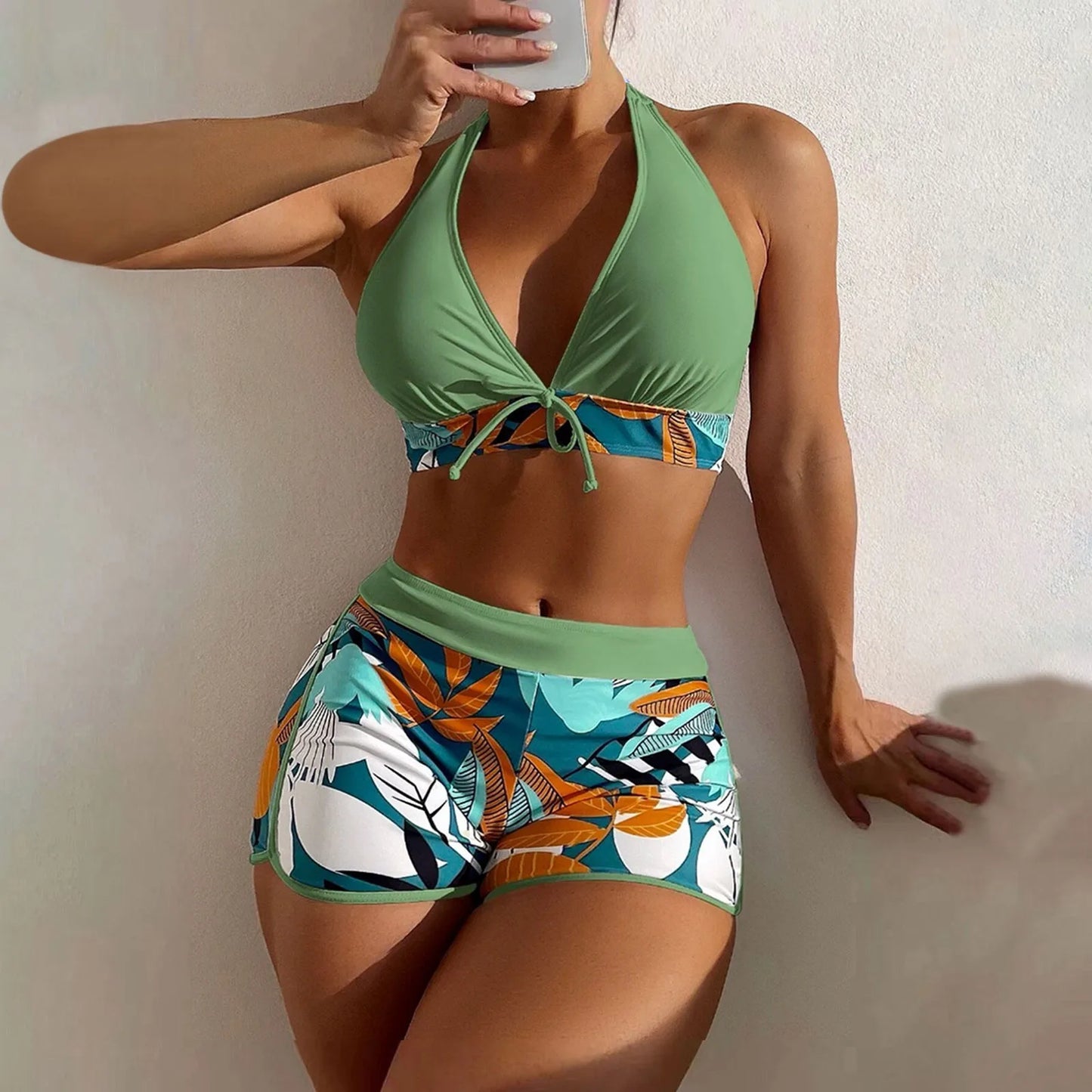 Woman wearing a High Waist Plant Print Bikini Set top and patterned shorts against a plain background