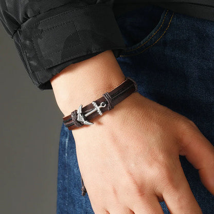 A man showcases a stylish leather bracelet featuring a prominent anchor design.