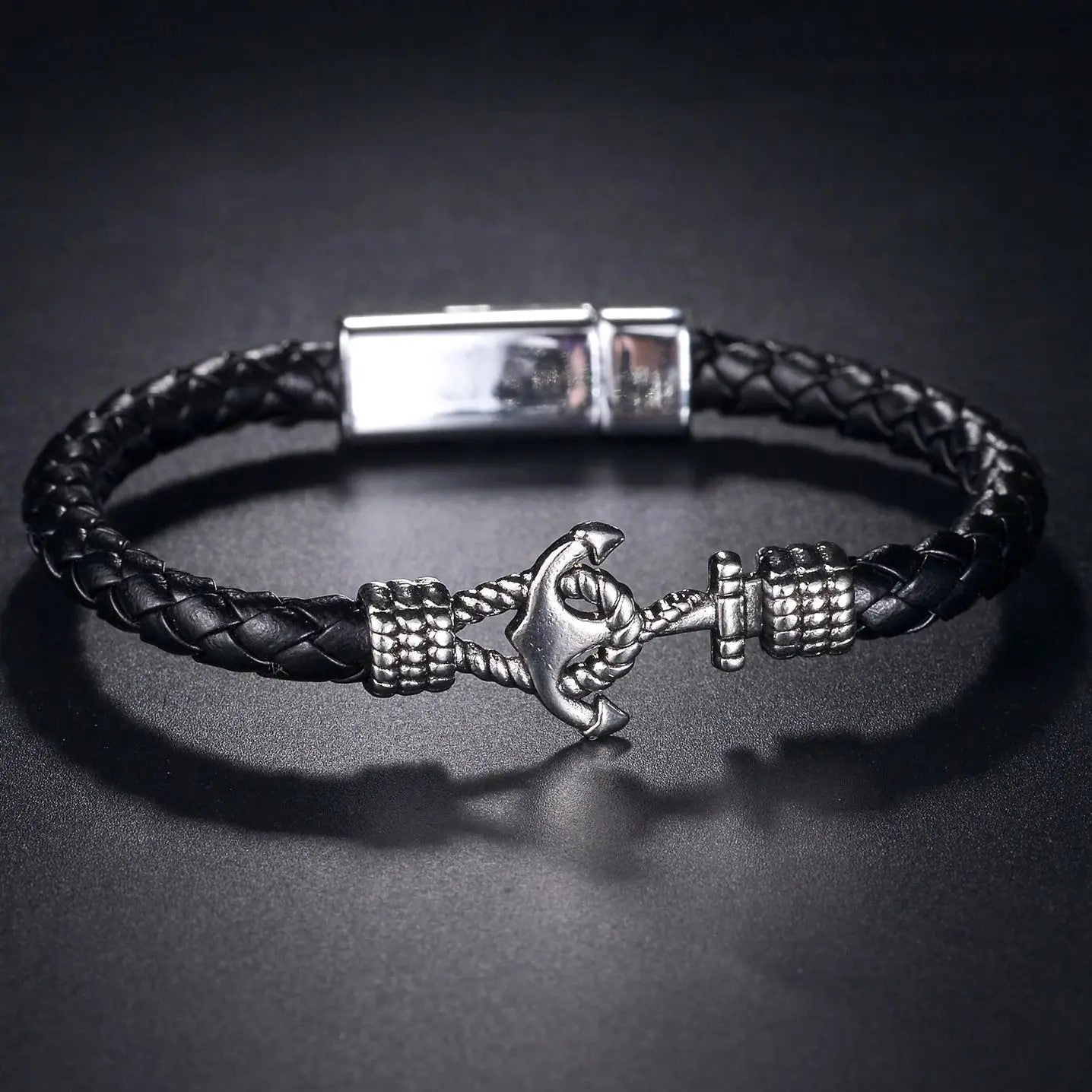 Black leather bracelet adorned with a silver anchor, combining elegance and a maritime touch for any outfit.