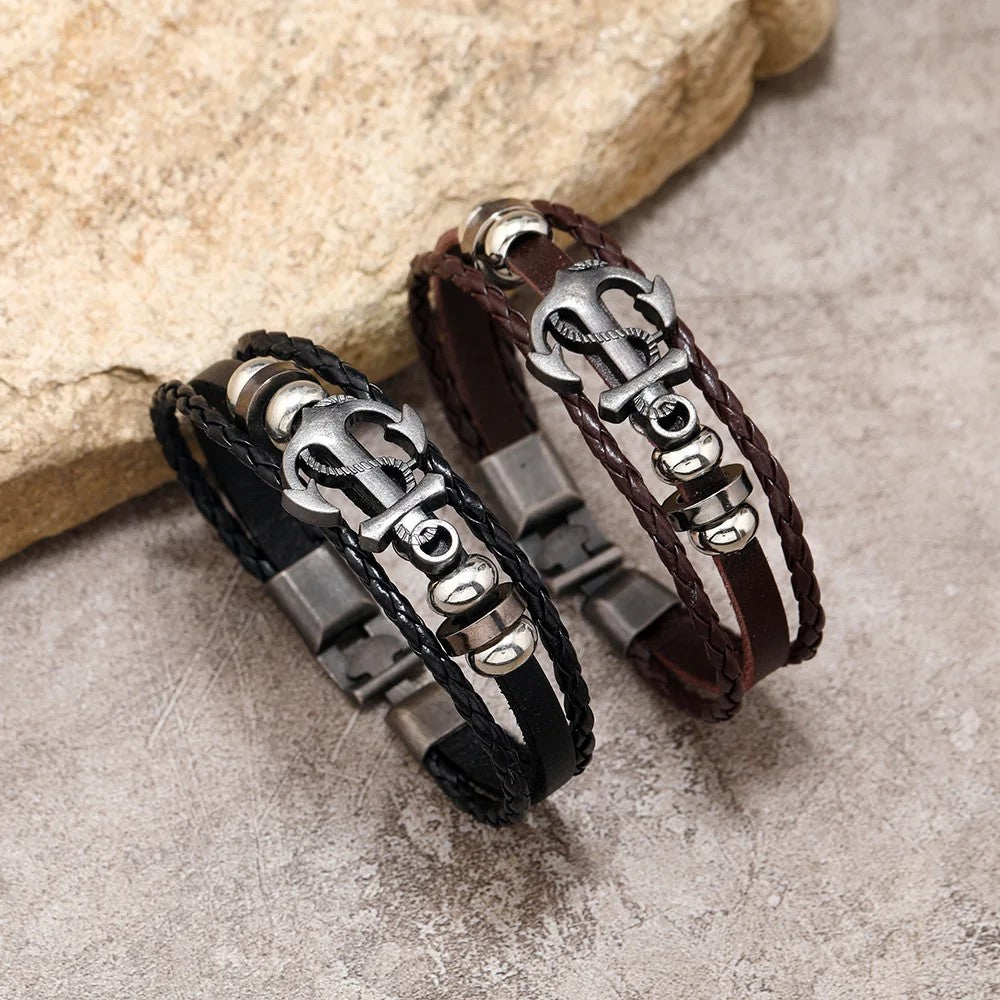 Two stylish leather bracelets adorned with unique metal charms, showcasing a blend of texture and elegance.