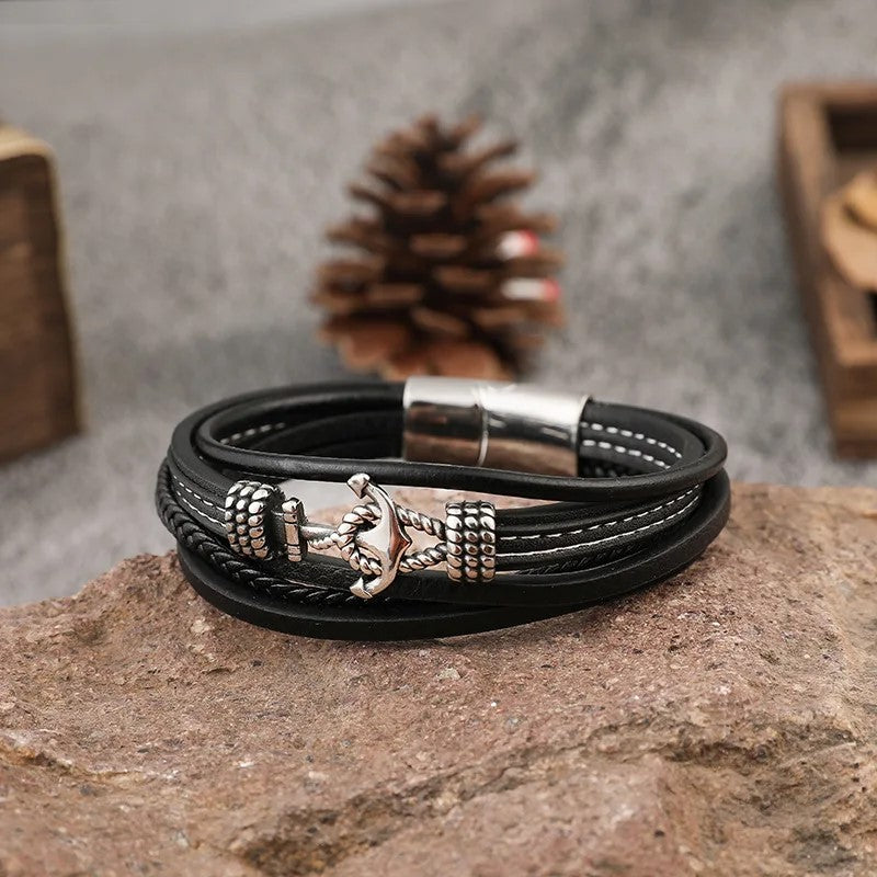 A stylish black leather bracelet featuring a prominent anchor design, perfect for nautical-themed accessories.