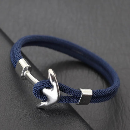 A stylish navy blue rope bracelet featuring a sleek silver anchor charm, perfect for nautical-themed accessories.