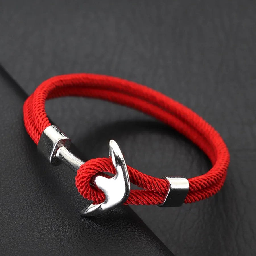 A vibrant red rope bracelet featuring a sleek silver anchor charm, perfect for nautical-themed accessories.