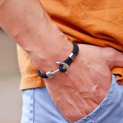 A man showcases a stylish bracelet featuring a prominent anchor design on his wrist.