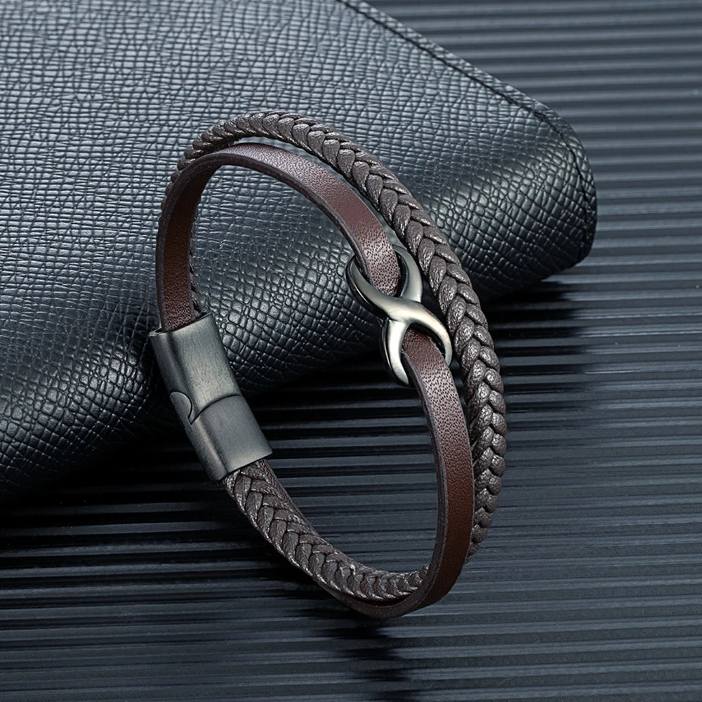 A leather bracelet adorned with a braided design, prominently featuring an Infinity Knot, symbolizing eternity and connection