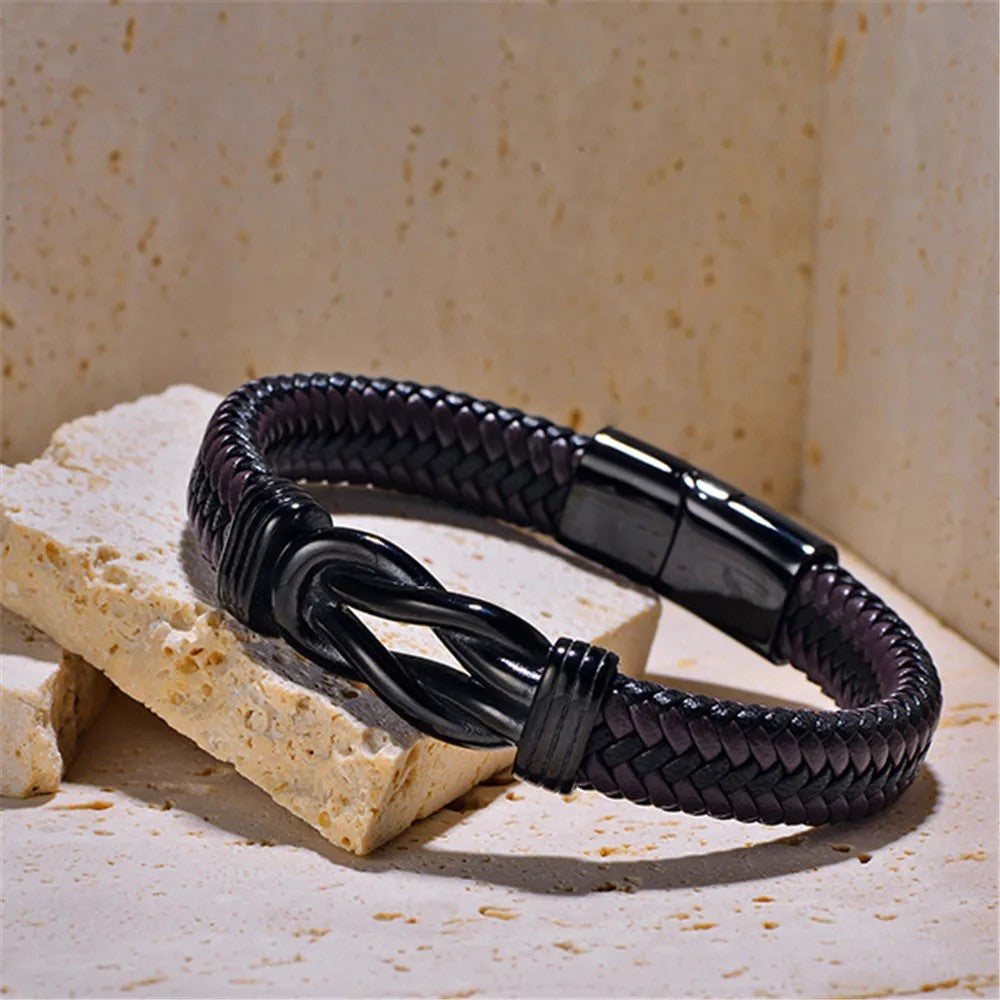 A stylish black braided leather bracelet with a matching black clasp, perfect for adding elegance to any outfit.