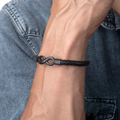 A man showcases a black bracelet adorned with an infinity symbol, symbolizing eternal connection and limitless possibilities.