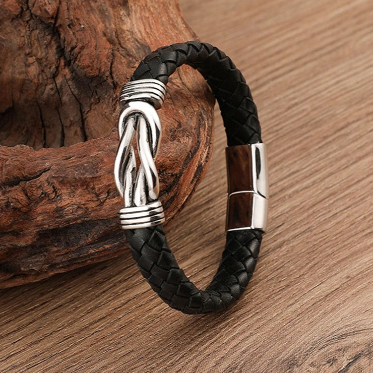 Stylish black leather infinity bracelet adorned with a silver clasp, combining modern design with timeless appeal.