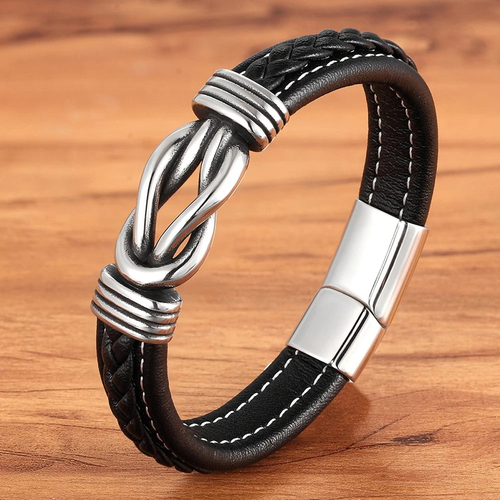 A black leather bracelet featuring a silver clasp, designed with an infinity knot motif for a stylish look.