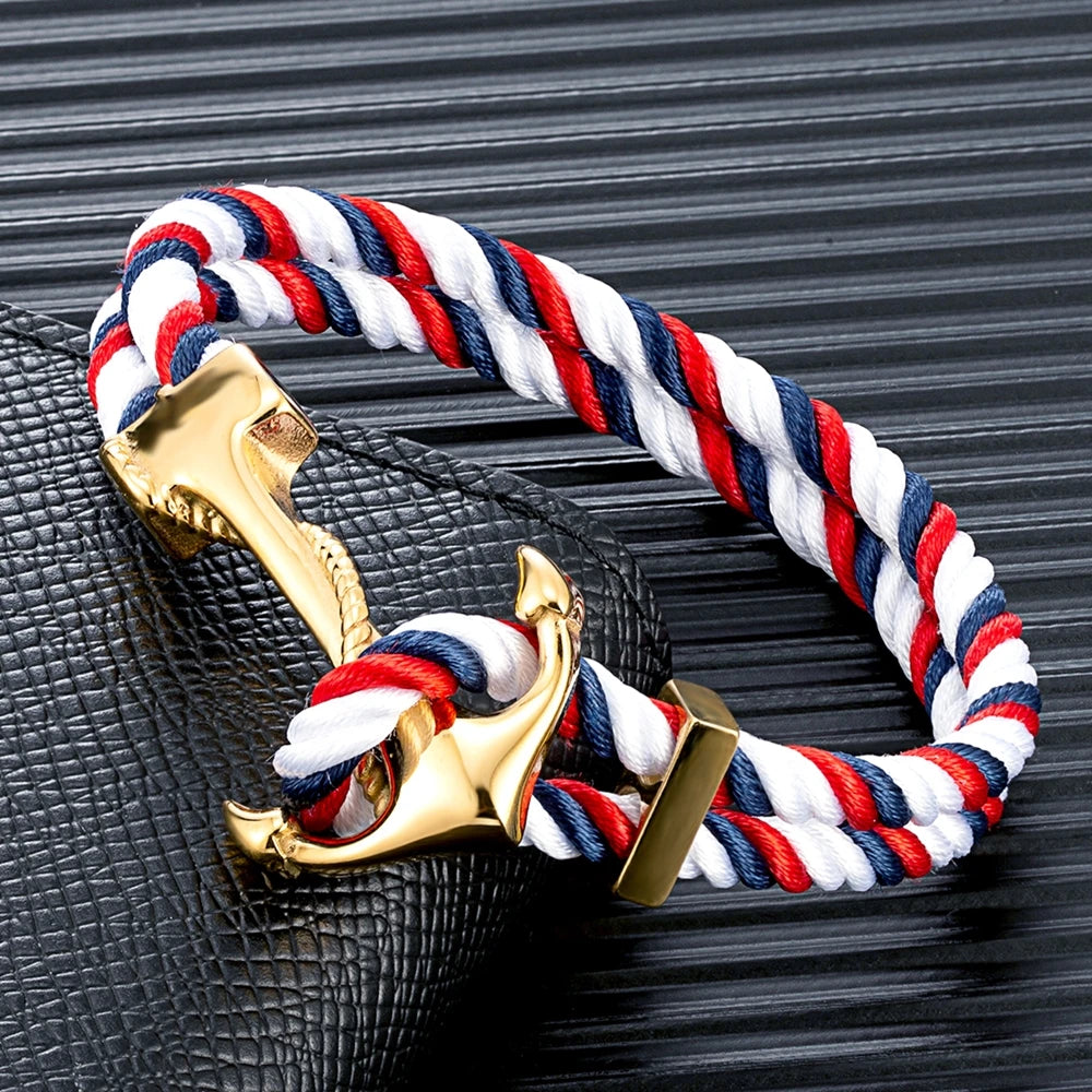 A red, white, and blue rope bracelet featuring a gold anchor charm, symbolizing nautical themes and patriotism.