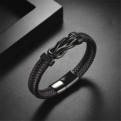 A chic black braided leather bracelet adorned with a black clasp, exemplifying contemporary fashion and craftsmanship.