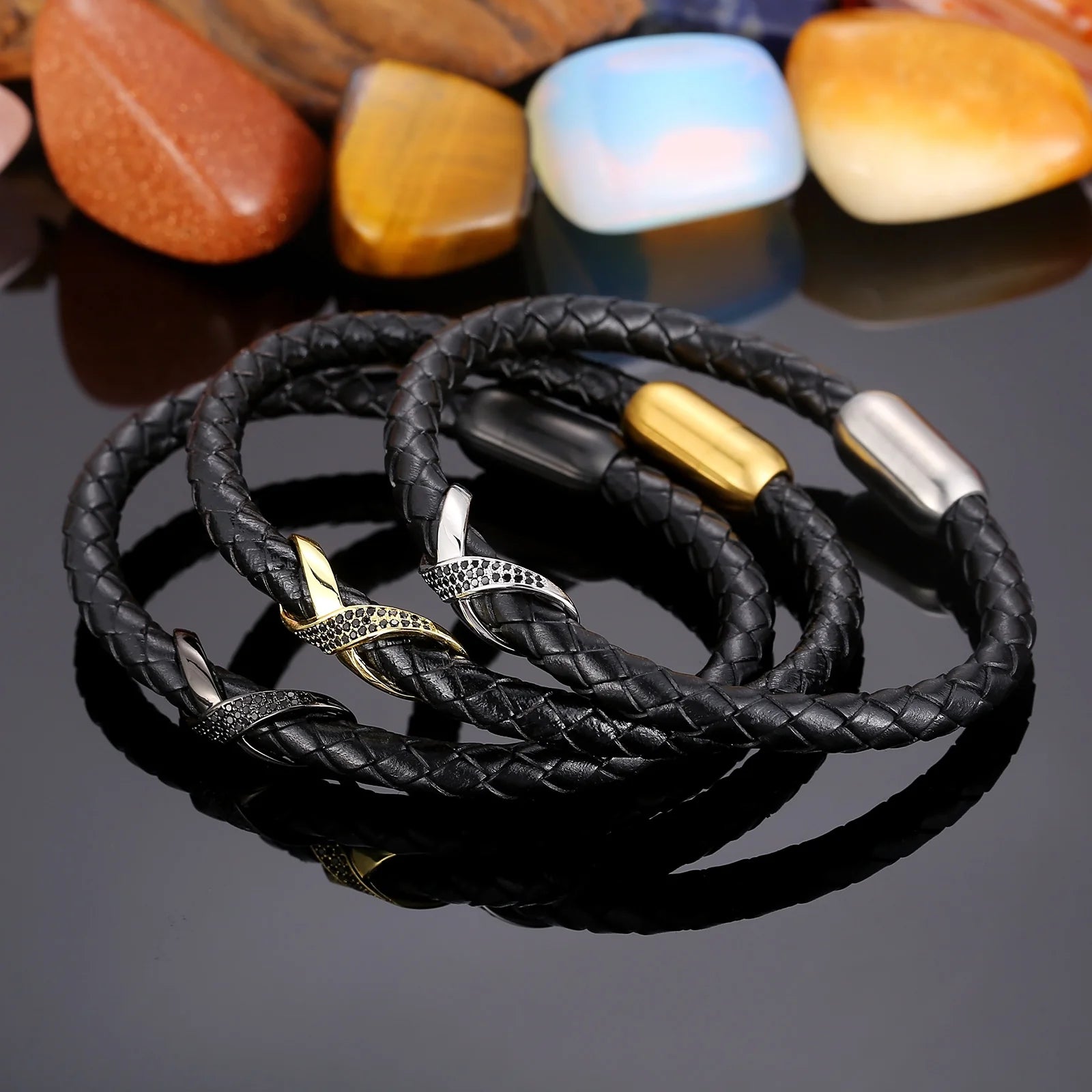 Three leather bracelets featuring gold and silver charms, including an infinity knot design, elegantly displayed together