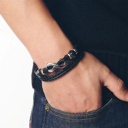 A man displaying a black leather bracelet on his wrist, illustrating a blend of sophistication and contemporary style