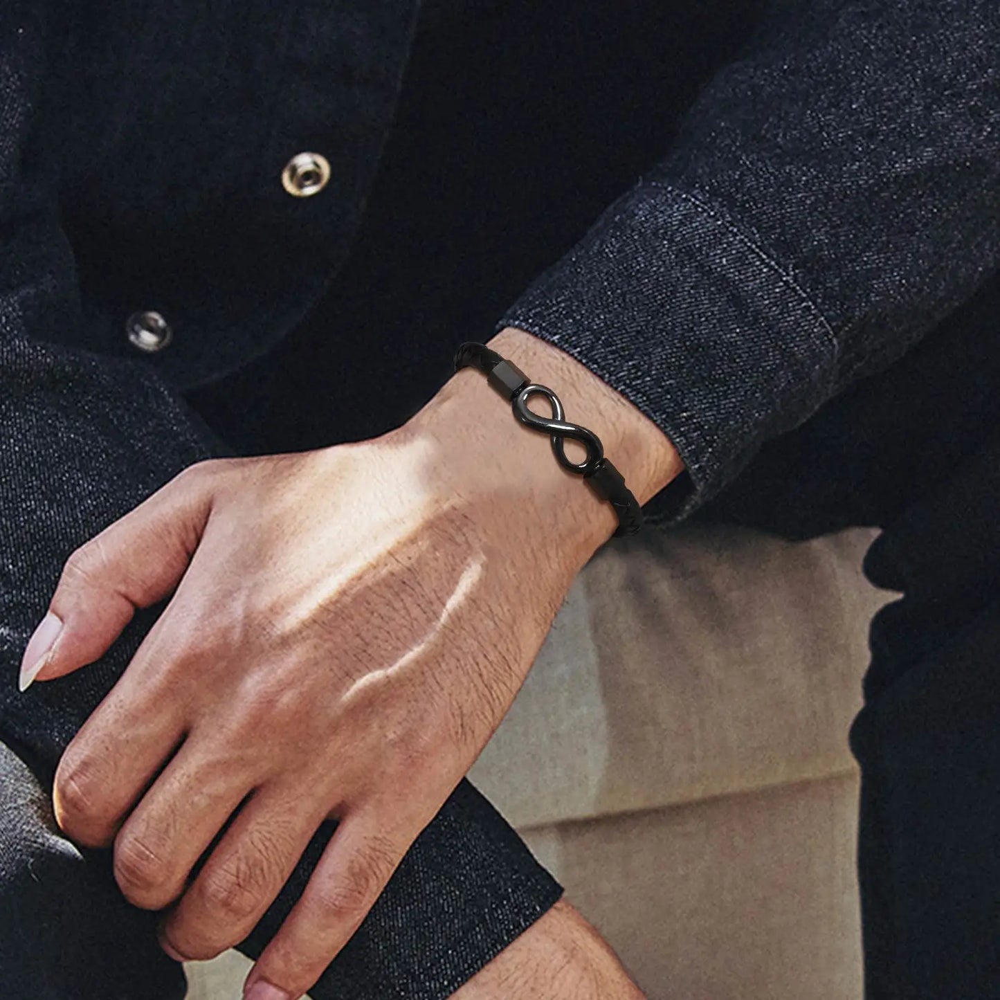  A close-up of a man's wrist adorned with a sleek black bracelet, emphasizing modern fashion.