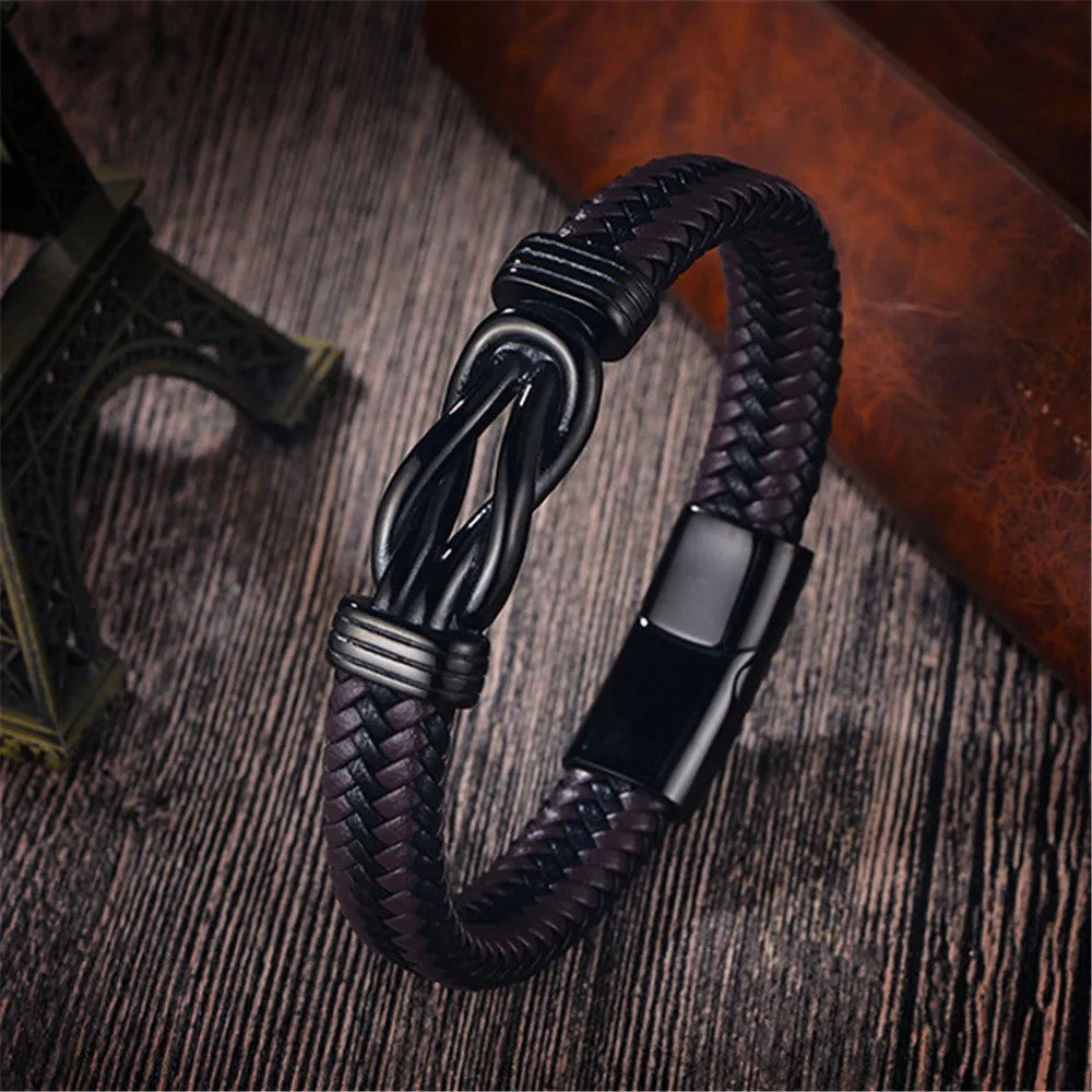 . A sophisticated black leather bracelet adorned with a black clasp, exemplifying contemporary fashion and craftsmanship.