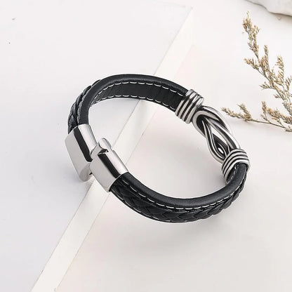  A black leather bracelet featuring a sleek silver clasp, showcasing a stylish and modern accessory for any outfit.