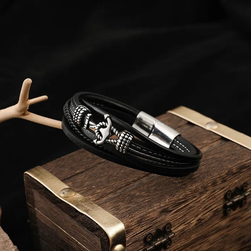 Black leather bracelet adorned with a silver anchor, combining elegance and a maritime touch in one accessory.