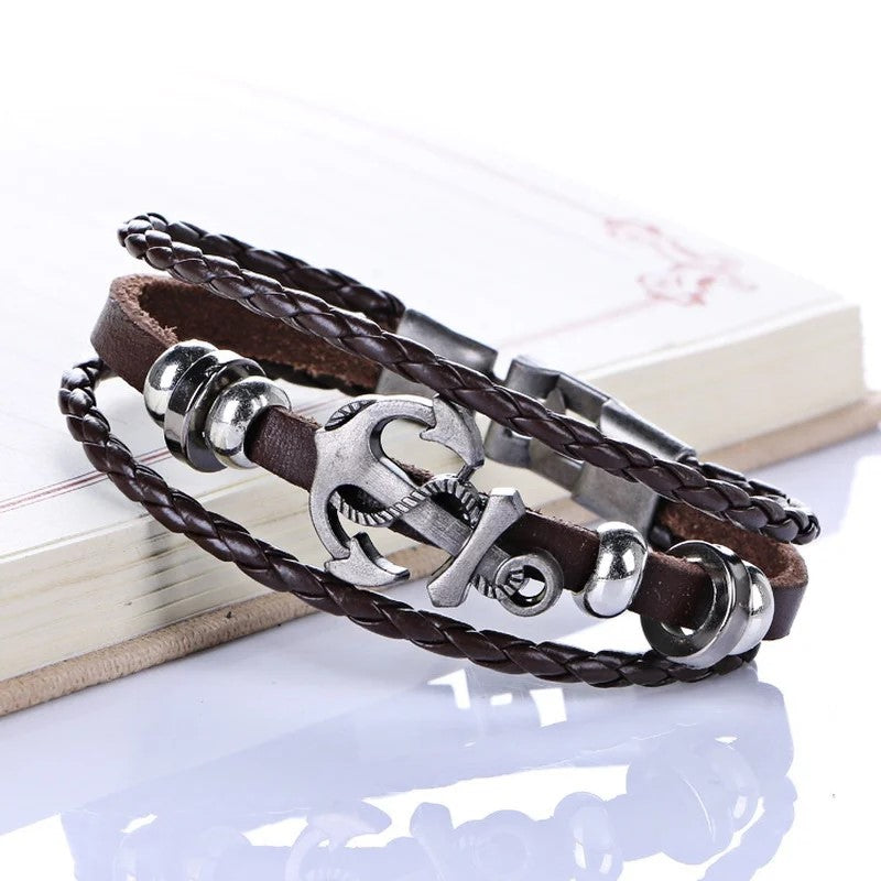 A stylish leather bracelet featuring a silver clasp and an anchor charm, perfect for nautical-themed accessories.