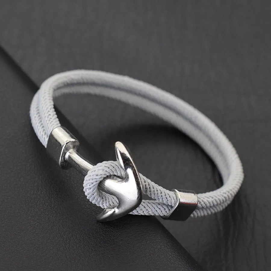 A stylish silver anchor bracelet paired with a sleek white cord, perfect for nautical-themed fashion.
