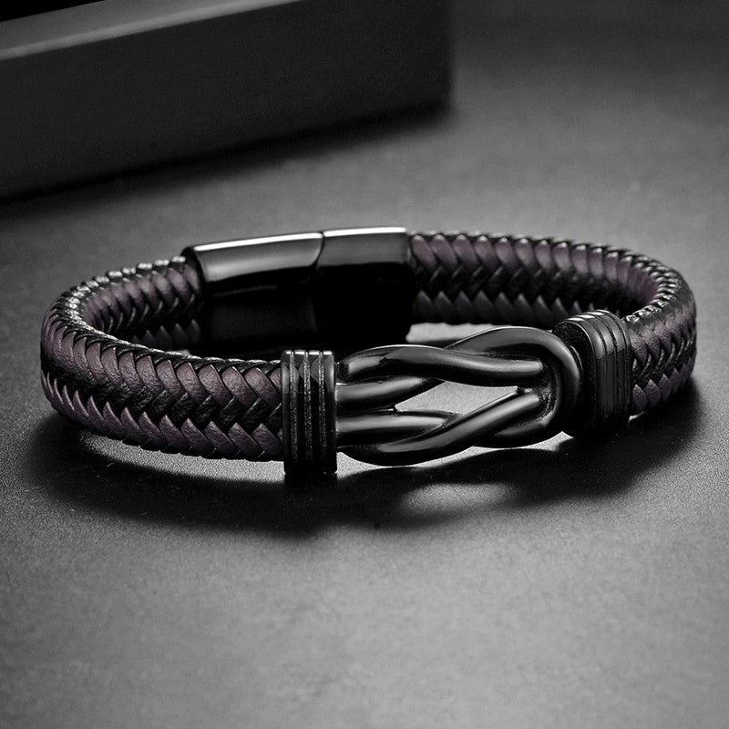 A black braided leather bracelet featuring a sleek black clasp, showcasing a stylish and modern design.