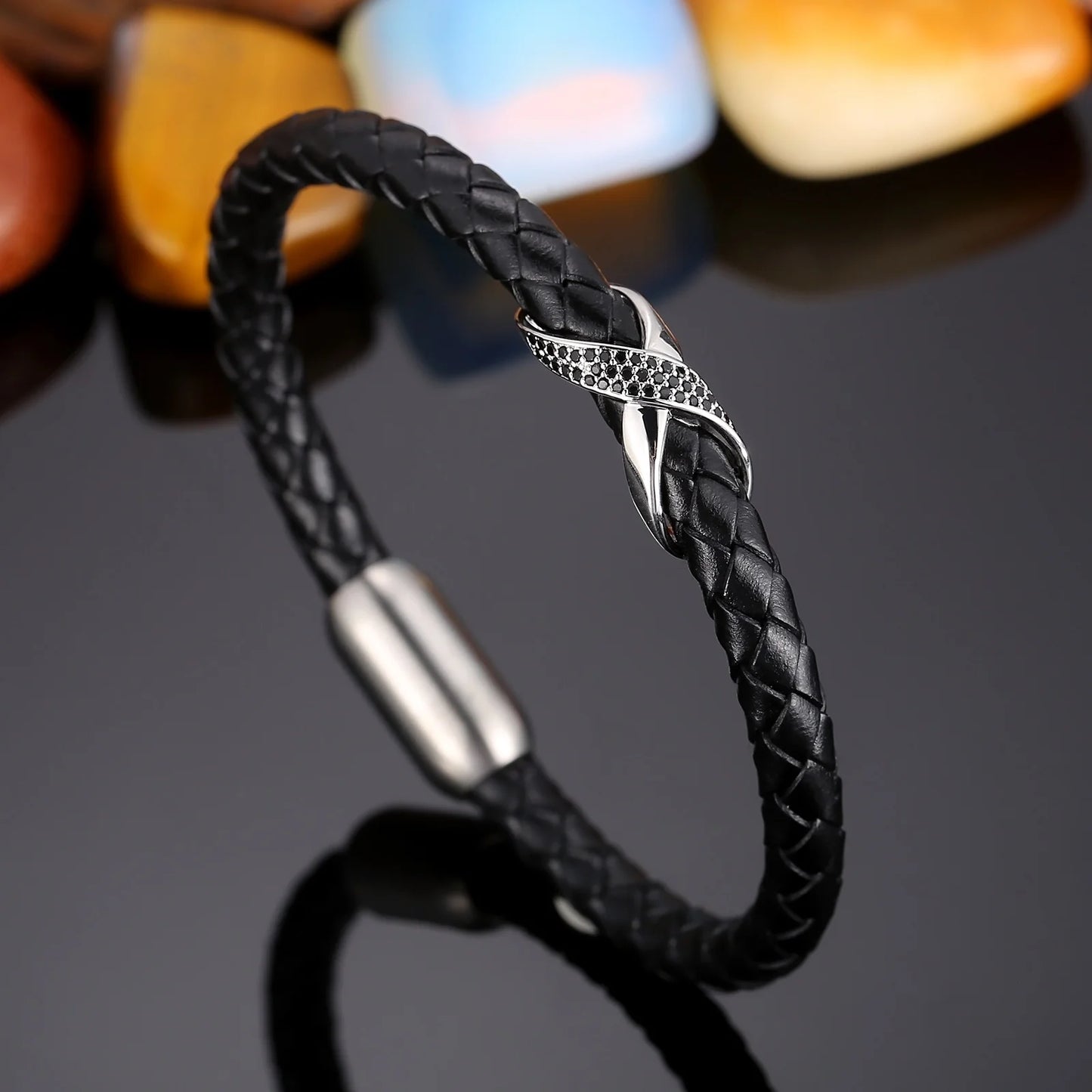 A black leather bracelet featuring a silver clasp, designed with an infinity knot motif for a stylish look