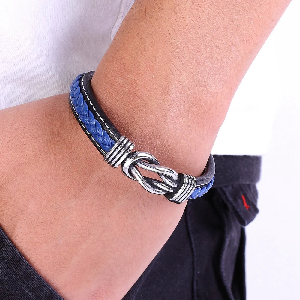 A man showcases a blue leather bracelet adorned with a silver clasp  Infinity Knot leather bracelet on his wrist 