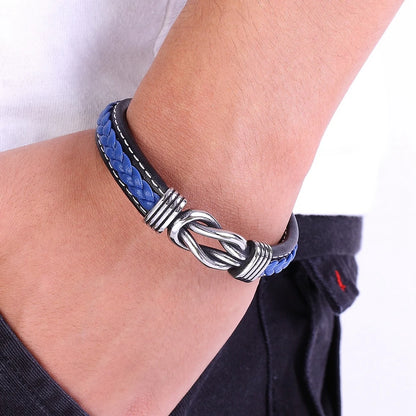 A man showcases a blue leather bracelet adorned with a silver clasp  Infinity Knot leather bracelet on his wrist 