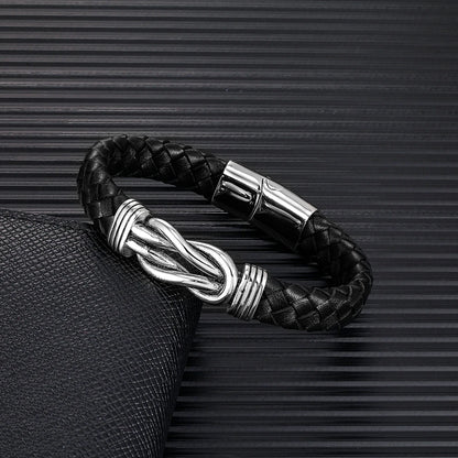  A black leather infinity bracelet featuring a sleek silver clasp, showcasing elegance and style in a minimalist design.