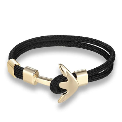 A stylish anchor bracelet featuring a black cord and elegant gold-plated brass accents, perfect for any outfit.