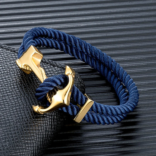 A navy rope bracelet featuring a gold anchor charm, symbolizing strength and nautical style.