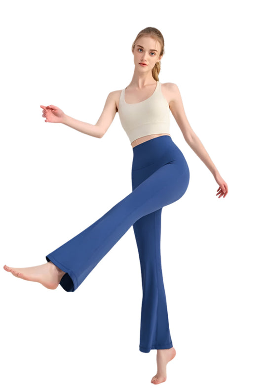 Woman wearing a white top and blue flared pants on a gray background