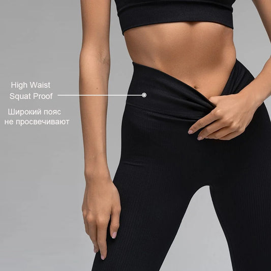 Person wearing black leggings with text highlighting 'High Waist' and 'Squat Proof' features on a gray background.