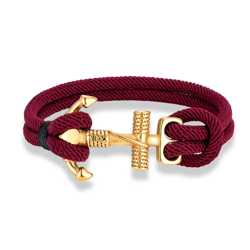 A gold plated stainless steel anchor charm bracelet with a red double strand nautical surfer rope.