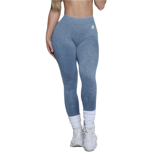 Person wearing blue leggings with a logo on a neutral background