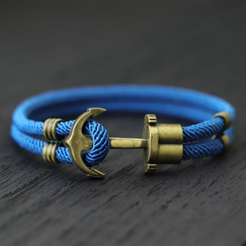 A blue rope bracelet featuring a stylish brass anchor charm, perfect for nautical-themed accessories.