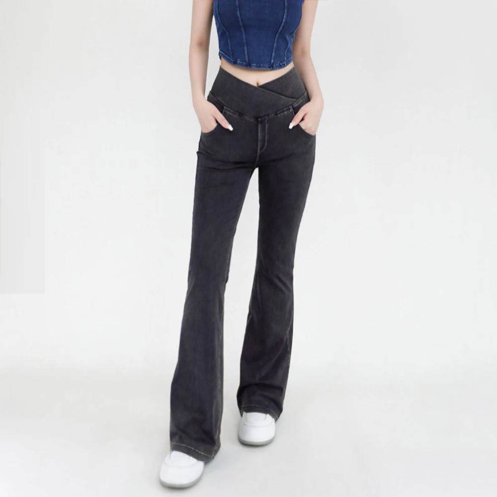 Person wearing black flared jeans on a white background