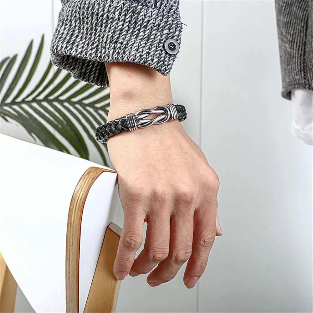 A person showcasing a leather infinity bracelet featuring a stylish black and silver design.