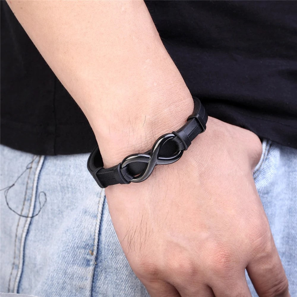 A man showcases a black leather bracelet adorned with an infinity symbol, symbolizing endless possibilities and connections.