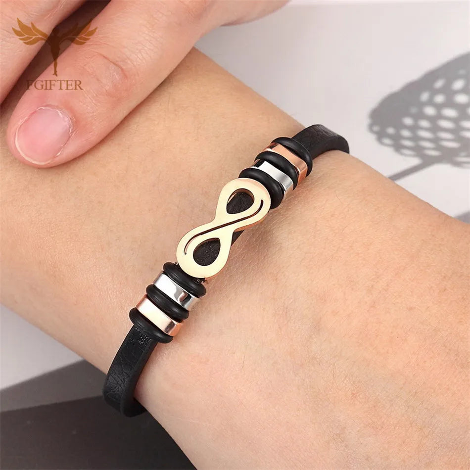 A woman showcases a black leather bracelet adorned with a gold infinity symbol, highlighting elegance and style.