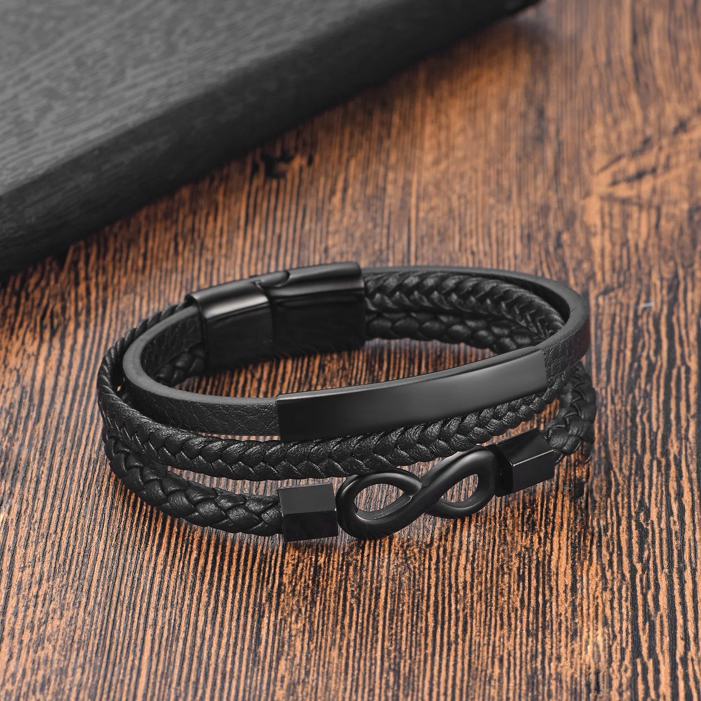 A black leather bracelet featuring a sleek infinity symbol, symbolizing endless love and connection.