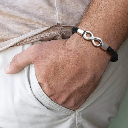 A man showcasing a bracelet adorned with an elegant infinity symbol, representing eternal love and connection.